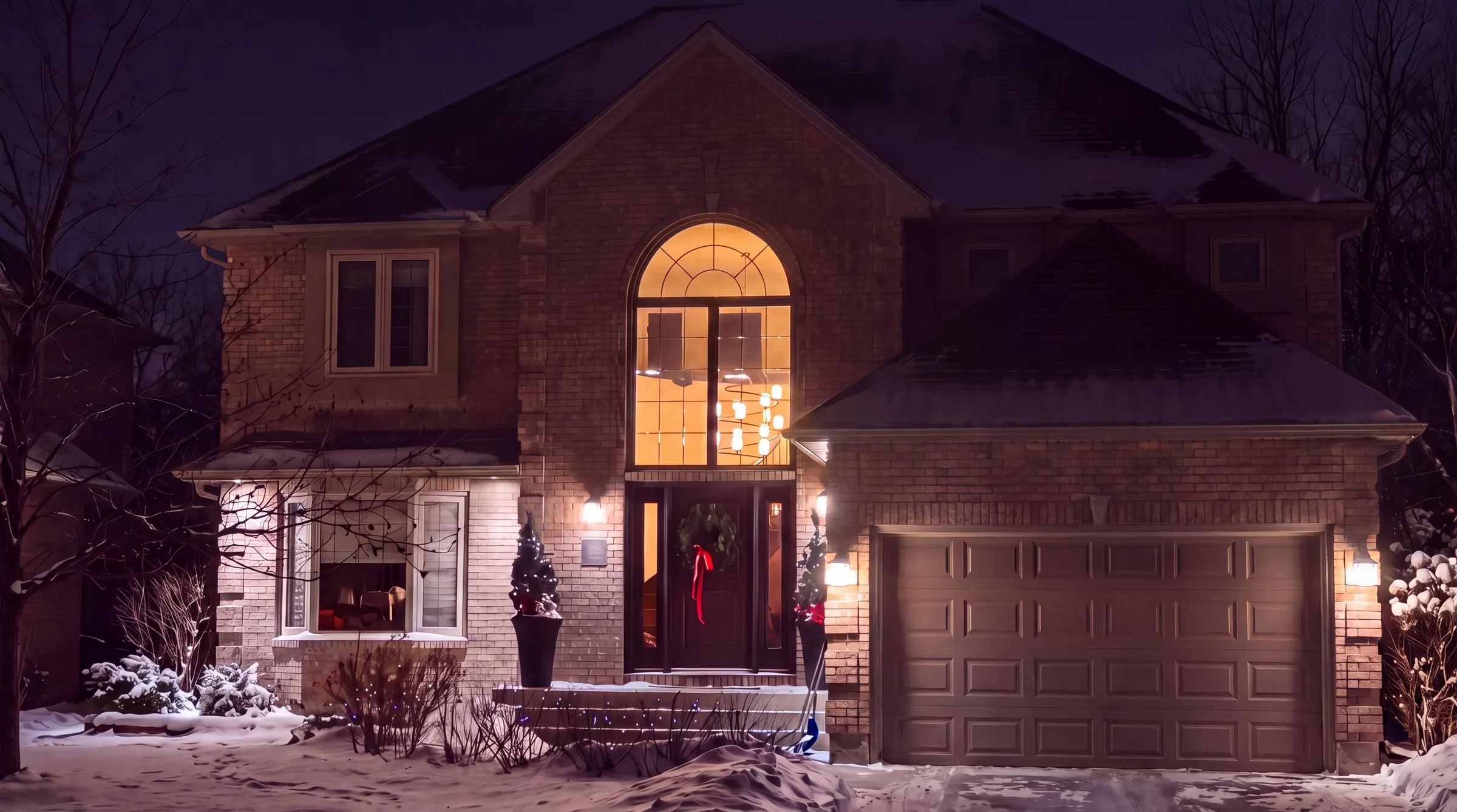The same Winnipeg brick two-storey home on a winter night before any lights or decorations go up