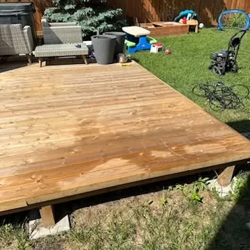 Freshly sealed wood deck on a Winnipeg lawn