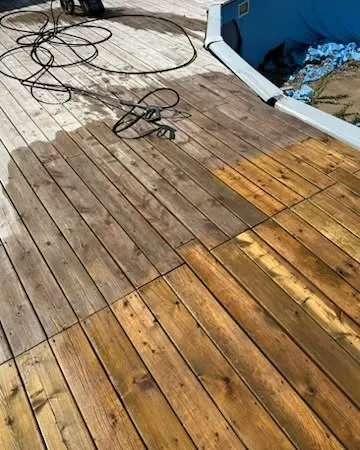 Wood deck in Winnipeg partly pressure washed, clean boards beside grey weathered ones