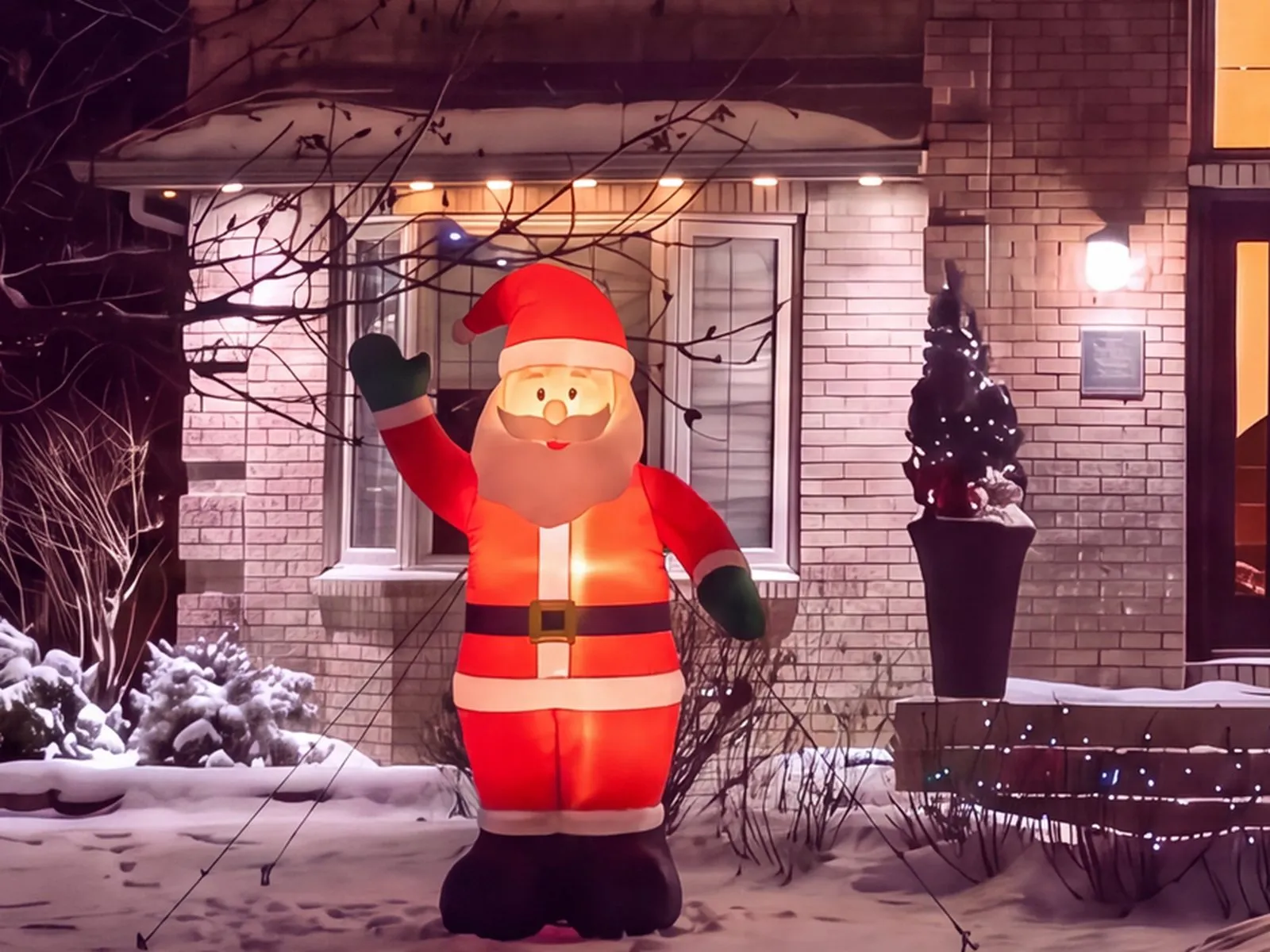 Inflatable Santa staked and tethered on a snowy Winnipeg front lawn beside the front steps