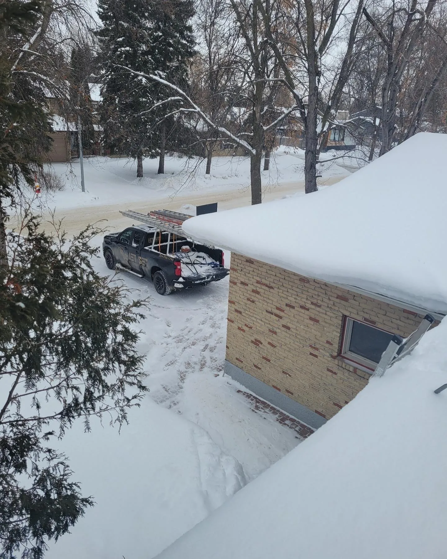 Jet Set truck on a snowy Winnipeg street beside a brick house with a snow-loaded roof